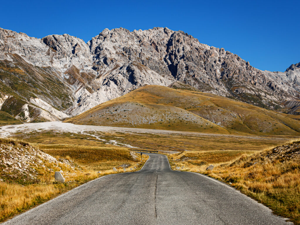 A road with mountains in the background in the Gran Sasso National park in Abruzzo.