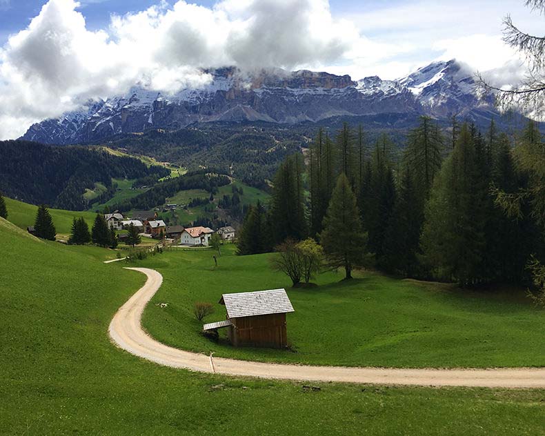 A dirt road with theDolomites in the background
