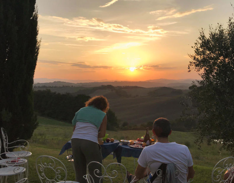 two people having aperitivo as the sun sets in Tuscany