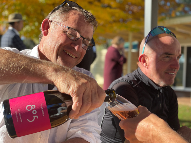 a man pouring a glass of sparkling rose