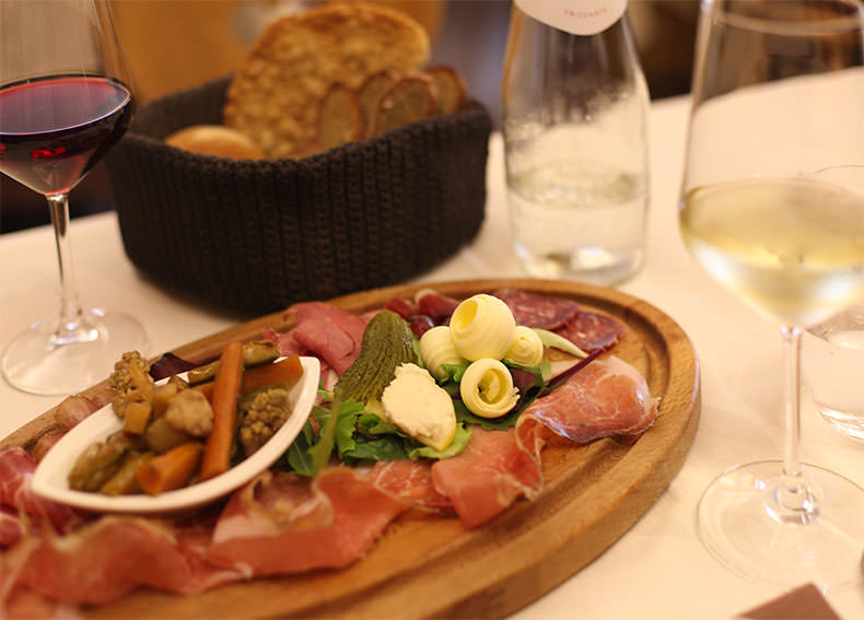 A glass of red and white wine and a salumi board