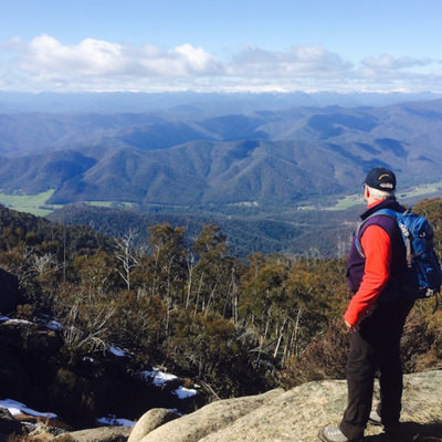 A man looking at the view of the valley from Mt Buffalo, Victoria