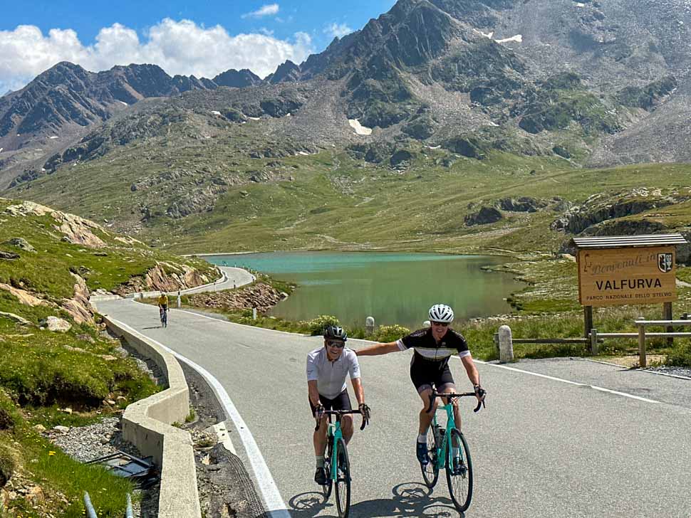 Two bikers in front of the lake at the top of Passo Gavia