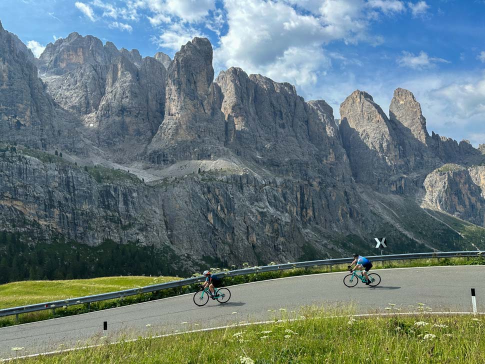 Two cyclists descending a mountain in the Dolomites, Italy