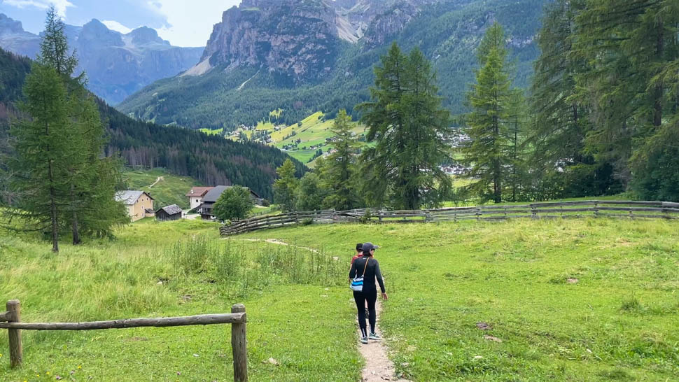 People hiking on a small path in the Dolomites