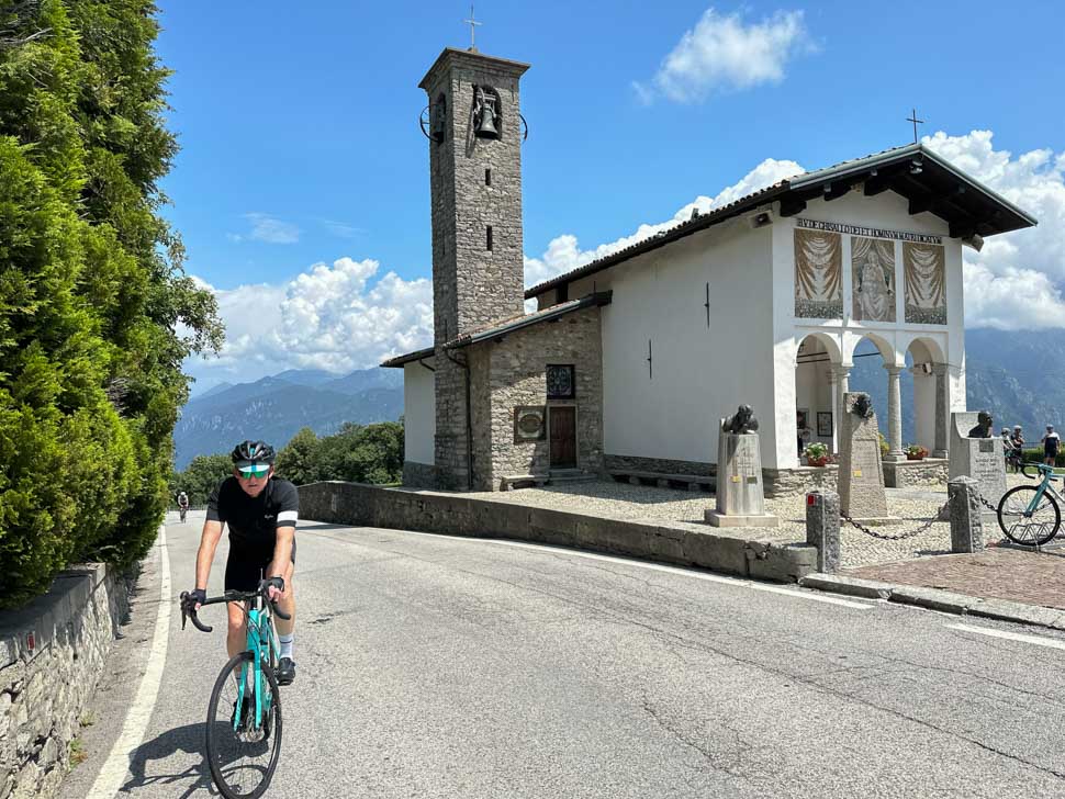 A rider cycling past the chapel at Madonna di Ghisallo Italy.
