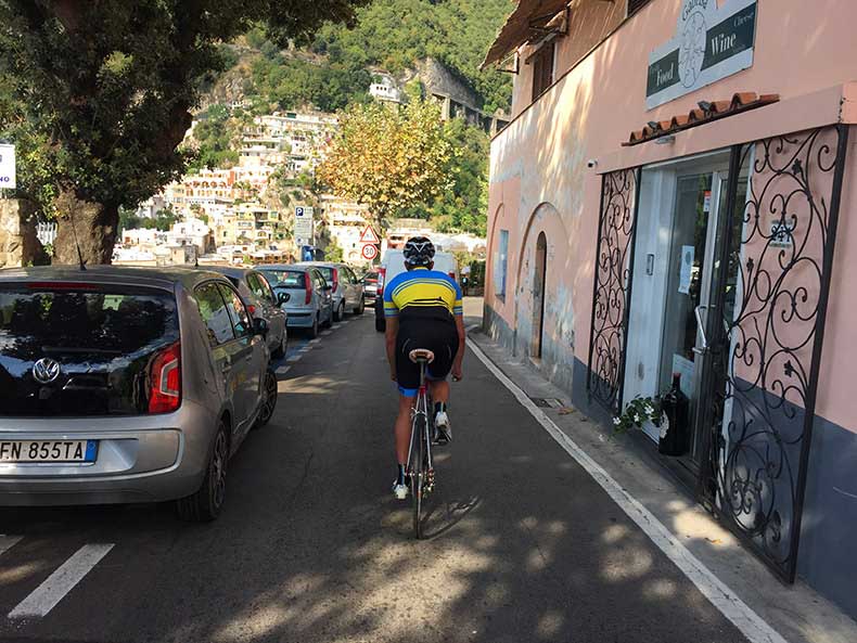 A cyclist riding into Positano