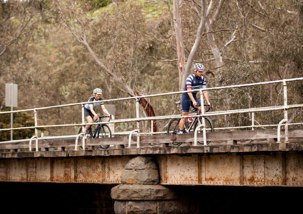 two cyclists riding over a bridge