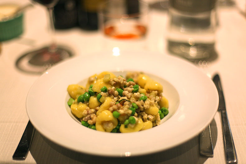 a bowl of gnocchi with rabbit and peas in Piemonte
