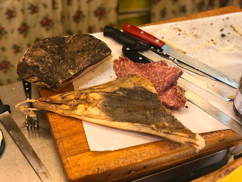 Italian cured meats and knives on a chopping board