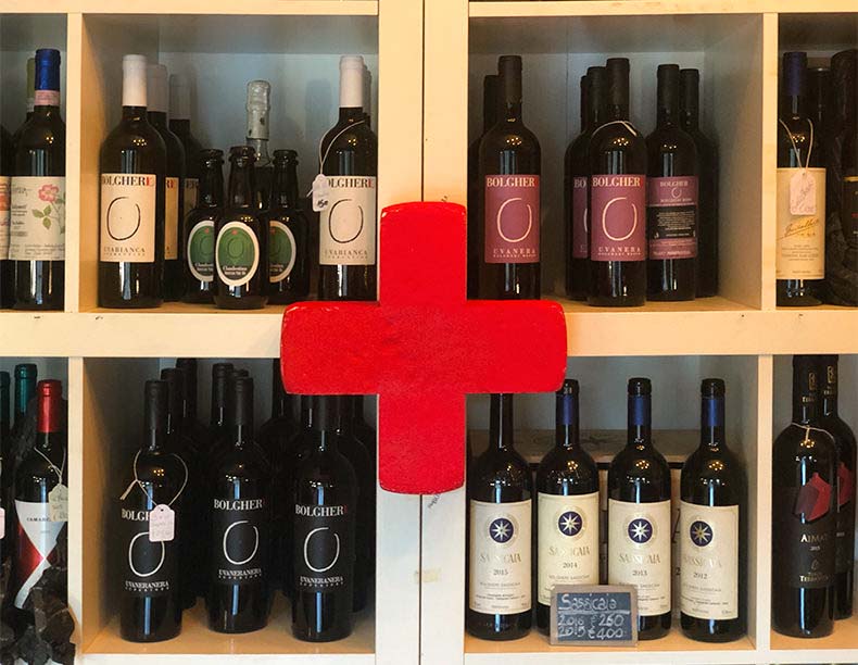 Italian wine bottle on a shelf with a first aid red cross