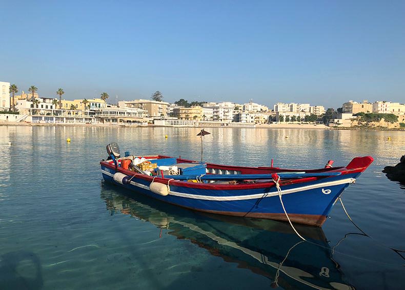 a woodne boast on the calm and crystal clear waters of Otranto