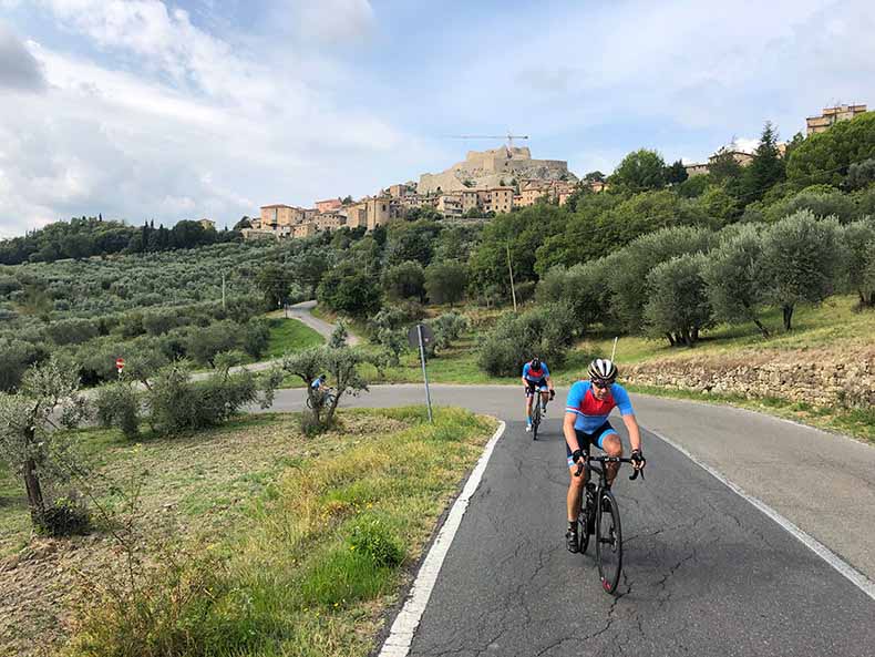 Two cyclist riding up a hill in Tuscany