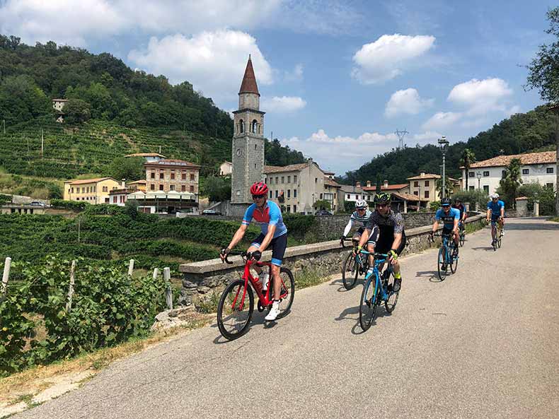 A group of cyclists riding along Prosecco road on a cycling holiday