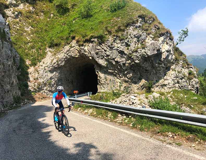a cyclist riding through a tunnel on his way to the top of Monte Grappa