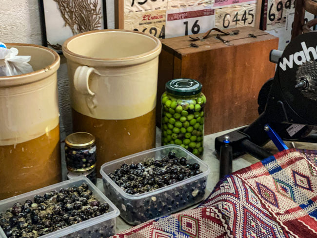 Olives curing in ceramic pots and glass jars