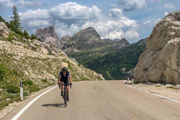 A cyclist riding to the top of Passo Valporola in the Dolomites