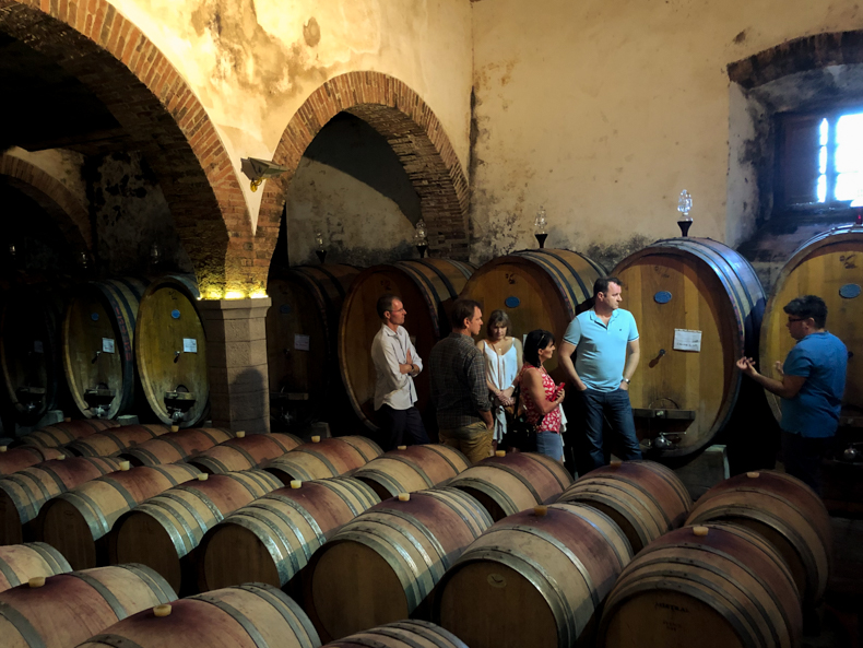 A cellar in Tuscany full of barrels filled with Chianti Classico