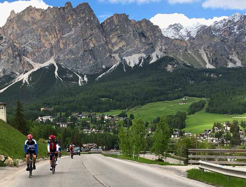 A group of cyclists riding up and out of Cortina d'Ampezzo