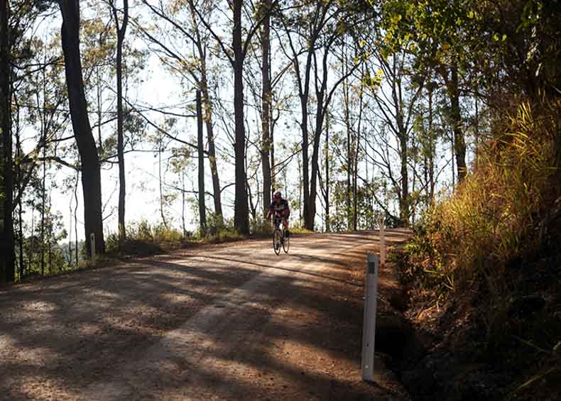 a cyclist riding on gravel near noosa