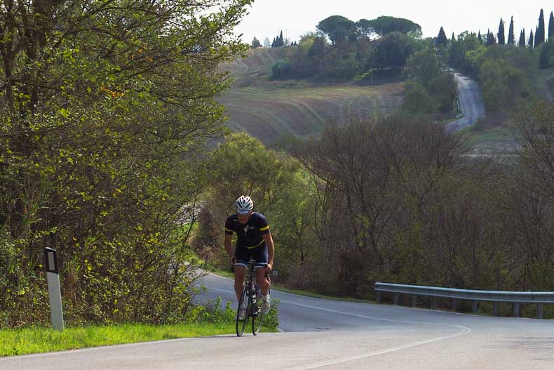 A cyclist riding inthe Tuscan hills