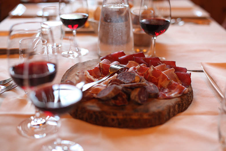 glasses of red wine and a mixed salumi board