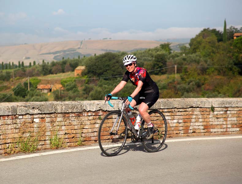A woman riding over a bridge in Tuscany