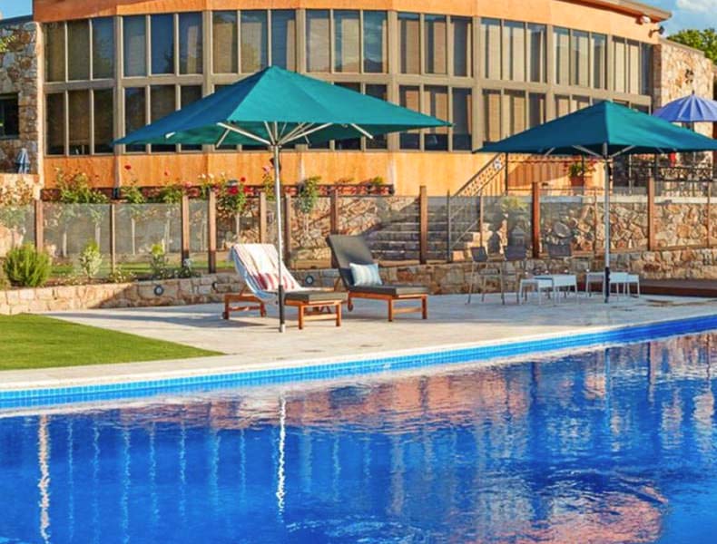 A pool with deck chairs and umbrella