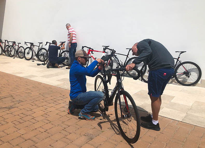 Two people adjusting the height of a hire bicycle on an Italian cycling holiday