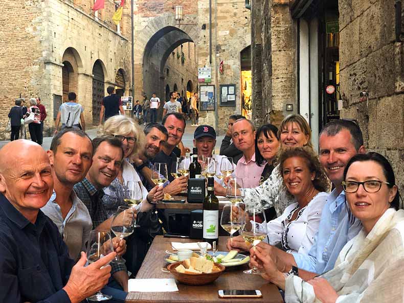 A group having aperitivo on the cobbled streets of San Gimignano