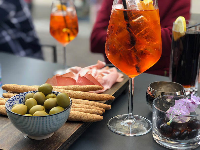 Aperol spritz, olives, grissini and speck