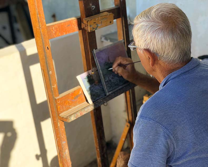 An Italian artist painting a seascape on a tile