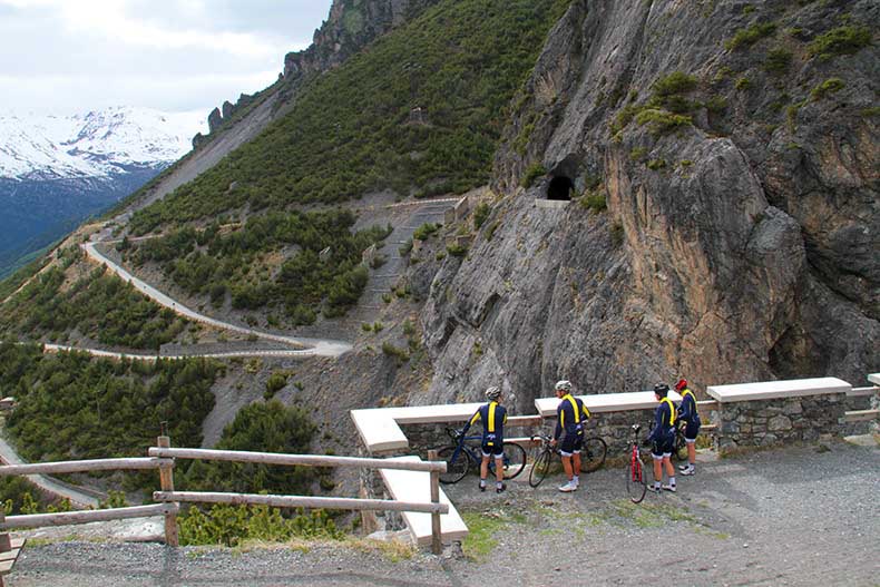 Three cyclist looking down on the climb of Cancano