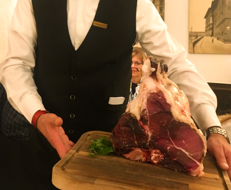 A waiter with a large Bistecca alla Fiorentina at at trattoria