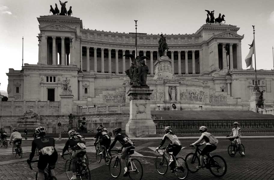 Cyclists riding past Victor Emmanuel II National Monument in Rome