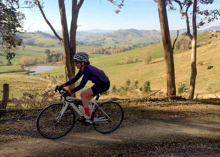 A woman riding a bicycle on gravel roads near Bright