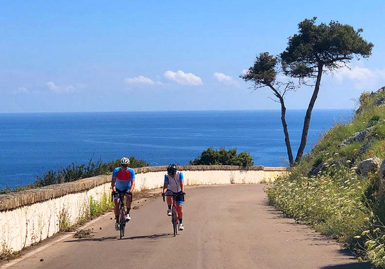 Two cyclist on a quiet seaside road in Puglia