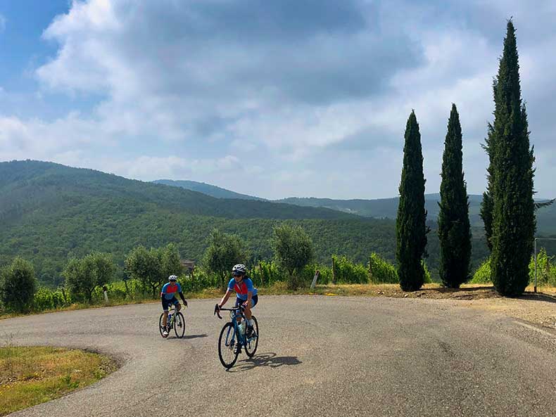 Two cyclist riding up a hill in Tuscany