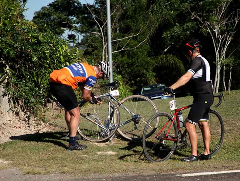 a cyclist changing a flat tyre on a bike