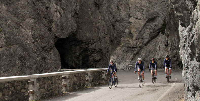 Cyclists riding through a tunnel on their way to Lago Cancano