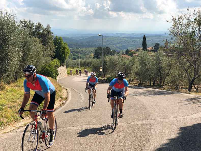 cyclists riding vintage steel bicycles in Tuscany