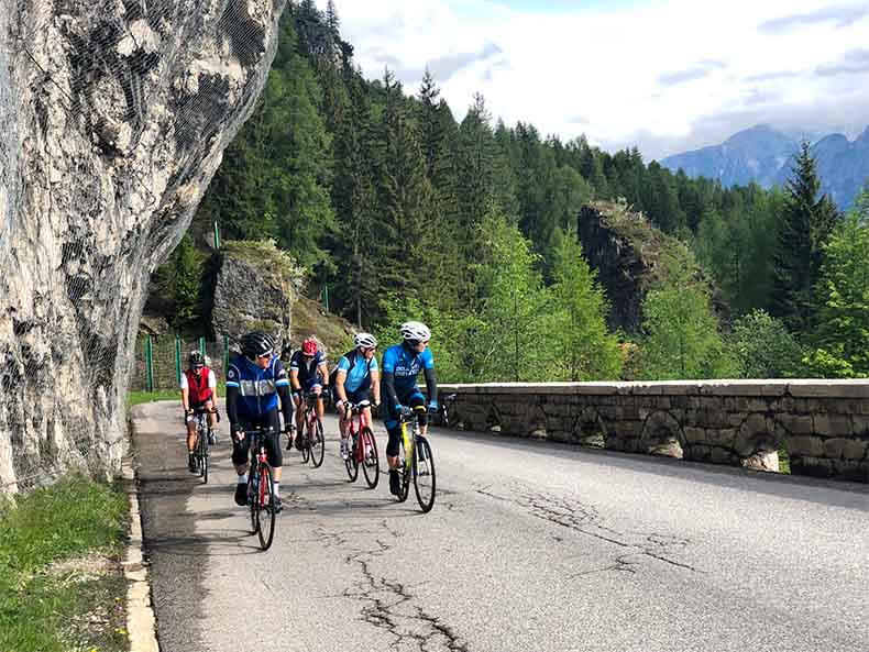 A group of riders looking athe village of Cortina d'Ampezzo as they climb to the top of Passo Falzarego