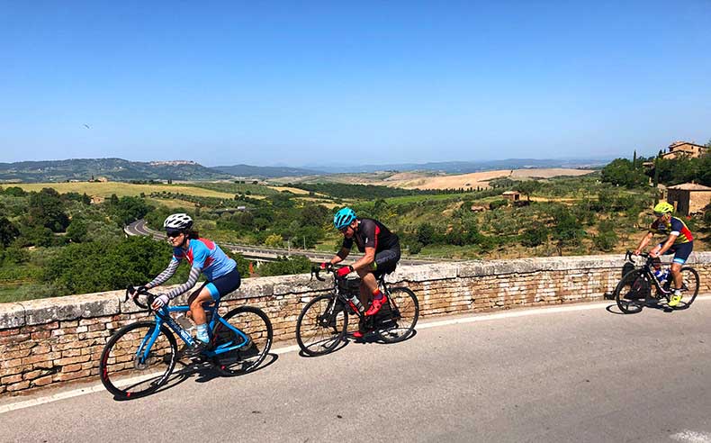 Cyclists riding across a bridge in Tuscany
