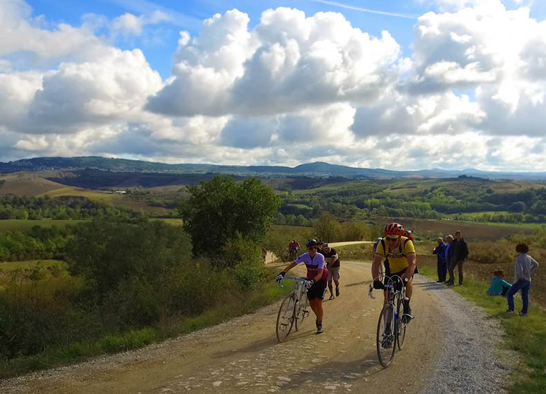 Cyclists walking and riding up a hill during L'Eroica