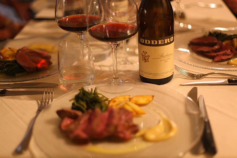A bottle of Barbaresco and two glasses of red wine with a dinner in Piemonte