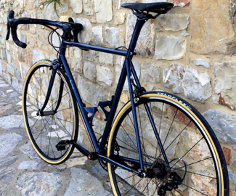 A steel bicycle against a wall