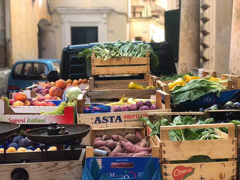 A small truck with wooden crates of fresh hocal vegetables