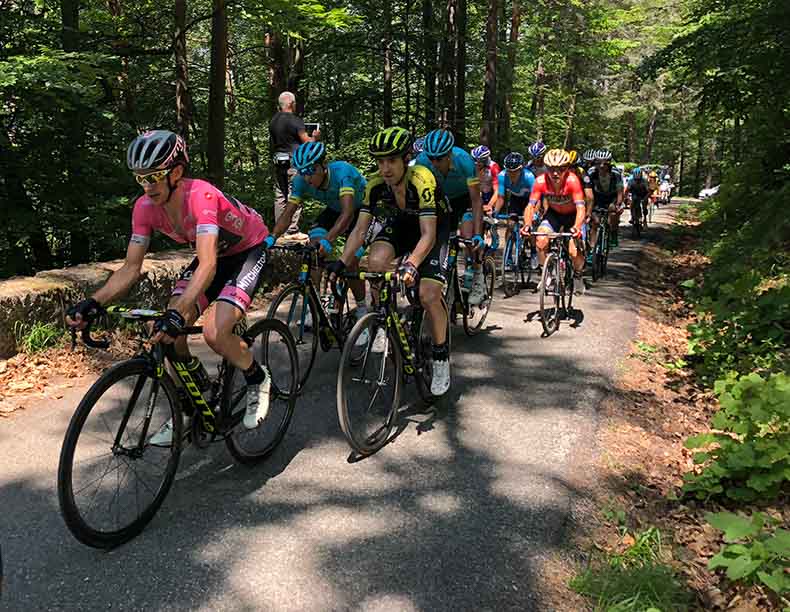 The pink leaders jersey racing on a small road in Italy