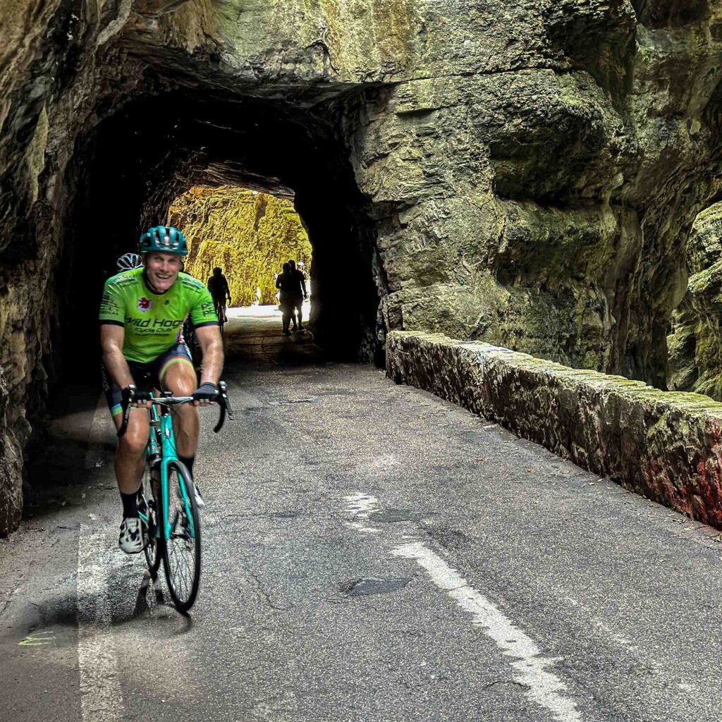 A group of riders cycling through a tunnel on an Italian cycling tour