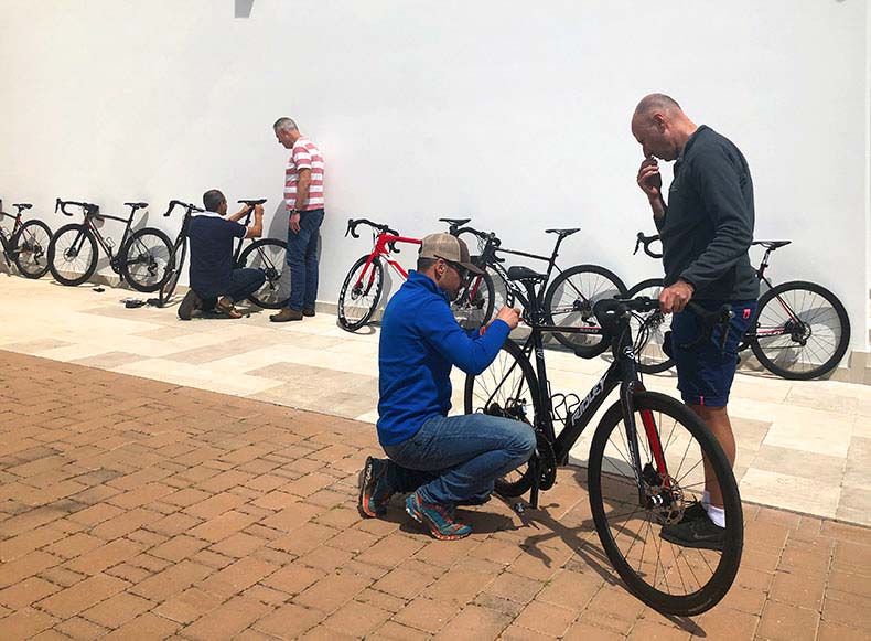 Two men adjusting the height of a hire bike in Italy